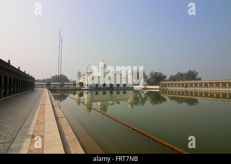 Gurdwara Lakhi Jungle nello stato indiano del Punjab riflessa nelle tranquille acque del Sarovar o pool di santo Foto Stock