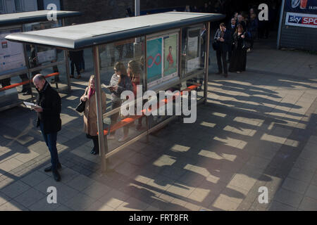 Le ombre dei pendolari in una coda stretching al di là di una fermata bus shelter a Waterloo, Londra centrale. Foto Stock