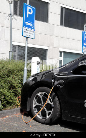 Un auto elettrica (Vauxhall Ampera) inserito in una strada laterale punto di carica di Arnhem, Paesi Bassi. Foto Stock