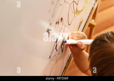 Bambino disegno a mano con un pennarello sulla lavagna Foto Stock