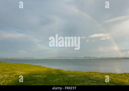 Rainbow visto dalla riva del lago del lago di Castiglione del Lago, Lago Trasimeno, provincia di Perugia, Umbria, Italia, Europa Foto Stock