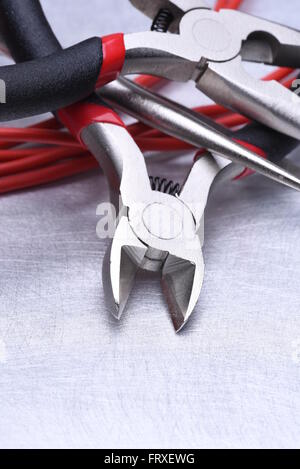 Strumenti per elettricista e i cavi grigio sulla superficie metallica Foto Stock