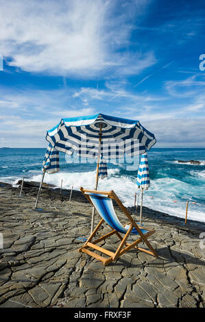 Sedia a sdraio e ombrelloni presso costa, Bagni Scogliera, Nervi, Genova, Liguria, Italia Foto Stock