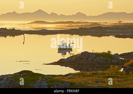 Del pescatore in barca il sole di mezzanotte vicino Lyngvaer, Isola di Austvagoy, Lofoten, Provincia del Nordland, Nordland, Norvegia, Europa Foto Stock