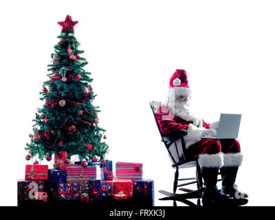 Una santa claus uomo utilizzando computer portatile silhouette isolati su sfondo bianco Foto Stock