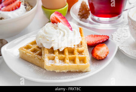 La prima colazione dolce con cialde, crema e fragole Foto Stock