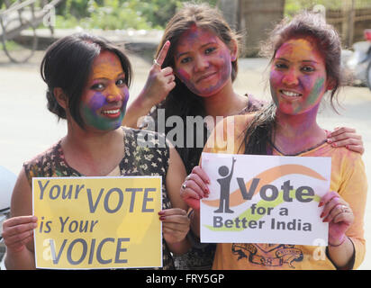 Sivasagar, Assam, India. 24 Mar, 2016. Indian bambine posano con playcards e sollecitare le persone a venire fuori e votare come si celebra holi, il festival dei colori in Sivasagar distretto di nord-orientale di stato di Assam il 24 marzo 2016. Migliaia di indiani gli elettori saranno chiamati ad eleggere i legislatori per la 126 sedi impugnata in 25.000 seggi elettorali nello Stato di Assam in due fasi il 4 aprile 11th. Credito: Luit Chaliha/ZUMA filo/Alamy Live News Foto Stock