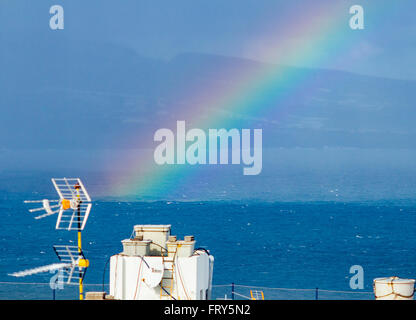 A Las Palmas di Gran Canaria Isole Canarie Spagna, 24 marzo 2016. Meteo: vista sopra i tetti a Las Palmas la captital di Gran Canaria come un arcobaleno moduli sopra l'Oceano Atlantico su un glorioso giovedì mattina nelle isole Canarie. Regno Unito premere viene segnalato che il Primo Ministro David Cameron e la famiglia sono in volo per le isole Canarie (Lanzarote) il 24 marzo per le loro vacanze di Pasqua. Il cancelliere della Germania, Angela Merkel, viene riportato anche per volare in una delle altre isole Canarie (La Gomera) per la sua vacanza di Pasqua. Credito: Alan Dawson News/Alamy Live News Foto Stock