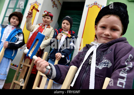 Lanzhot, Repubblica Ceca. 24 Mar, 2016. I bambini in Moravia abito tradizionale a piedi con i loro sonagli attraverso il centro di Lanzhot, Repubblica Ceca su Maundy (santo) Giovedì, 24 marzo 2016. Rattles sostituire il suono delle campane che sono secondo la tradizione liturgica a volare su Maundy (santo) Giovedì a Roma. © Vaclav Salek/CTK foto/Alamy Live News Foto Stock