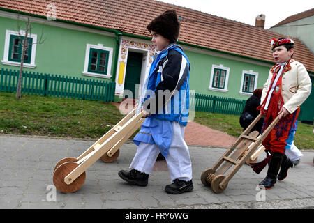 Lanzhot, Repubblica Ceca. 24 Mar, 2016. I bambini in Moravia abito tradizionale a piedi con i loro sonagli attraverso il centro di Lanzhot, Repubblica Ceca su Maundy (santo) Giovedì, 24 marzo 2016. Rattles sostituire il suono delle campane che sono secondo la tradizione liturgica a volare su Maundy (santo) Giovedì a Roma. © Vaclav Salek/CTK foto/Alamy Live News Foto Stock