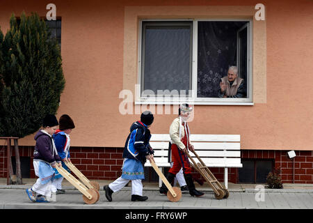 Lanzhot, Repubblica Ceca. 24 Mar, 2016. I bambini in Moravia abito tradizionale a piedi con i loro sonagli attraverso il centro di Lanzhot, Repubblica Ceca su Maundy (santo) Giovedì, 24 marzo 2016. Rattles sostituire il suono delle campane che sono secondo la tradizione liturgica a volare su Maundy (santo) Giovedì a Roma. © Vaclav Salek/CTK foto/Alamy Live News Foto Stock