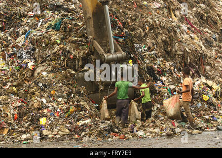 Dacca in Bangladesh. Il 24 marzo 2016. Bambino raccoglitori di rifiuti pick non- rifiuti biodegradabili per essere utilizzato per l'industria del riciclaggio in cantiere di dump di Dhaka. Si tratta di un posto che in garantito a riprodurre il caos con le ghiandole olfattive dei passanti. Il sgradevoli terra con niente ma garbage distribuite su una vasta area, indurre vertigini e una cefalea pulsante in una persona media con in pochi minuti. Foto Stock