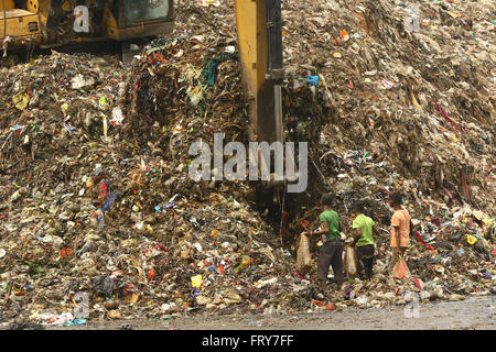 Dacca in Bangladesh. Il 24 marzo 2016. Bambino raccoglitori di rifiuti pick non- rifiuti biodegradabili per essere utilizzato per l'industria del riciclaggio in cantiere di dump di Dhaka. Si tratta di un posto che in garantito a riprodurre il caos con le ghiandole olfattive dei passanti. Il sgradevoli terra con niente ma garbage distribuite su una vasta area, indurre vertigini e una cefalea pulsante in una persona media con in pochi minuti. Foto Stock