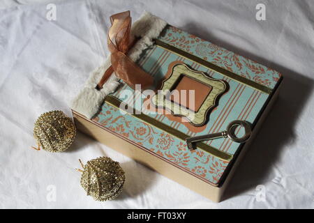 Coperta in legno di colore chiaro scrigno di velluto in forma di libro con golden key e due sfere Foto Stock