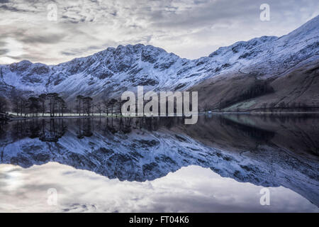 Buttermere riflessioni a sunrise su un gelido inverno mattina. Lake District, England, Regno Unito Foto Stock