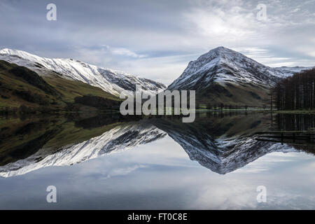 Buttermere riflessioni a sunrise su un gelido inverno mattina. Lake District, England, Regno Unito Foto Stock