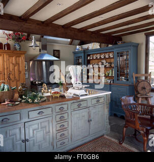 Vintage bilance di pesatura su unità montate con lime lavato porte in degli anni novanta di travi di cucina di paese Foto Stock