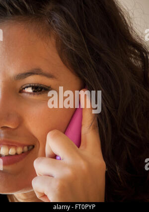 Sorridente giovane donna ispanica tramite telefono cellulare - Puerto Vallarta, Messico #613PV Foto Stock