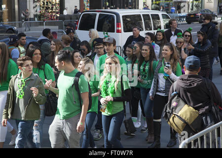 Un mare di gente molti in verde versare sulla 5th Ave. a 42nd Street per l annuale San Patrizio Parade di New York City. Un gruppo di ragazzi tutti in verde a piedi per la parata. Foto Stock