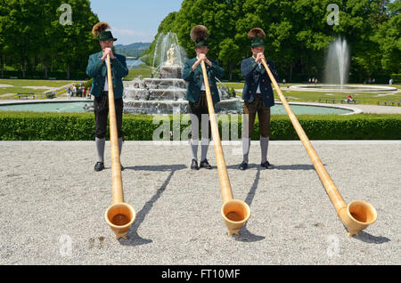 Bavaresi tradizionali soffianti alphorn, Schloss Herrenchiemsee, Chiemsee, Chiemgau, Alta Baviera, Germania Foto Stock