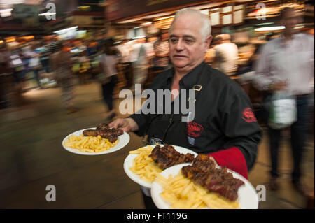 Cameriere serve bistecche e patatine fritte, Parilla tipo ristorante, Mercado del Puerto, Montevideo, Montevideo, Uruguay Foto Stock