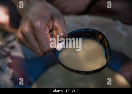 Mano che tiene aperto un guscio di noce di cocco con la kava durante un Kava cerimonia potabile nel villaggio, Malolo Lailai island, Isole della Mamanuca, Figi e Sud Pacifico Foto Stock