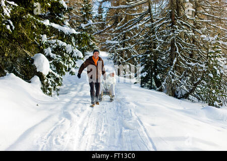 L'uomo tirando una donna seduta su una slitta, Muehlen, Stiria, Austria Foto Stock