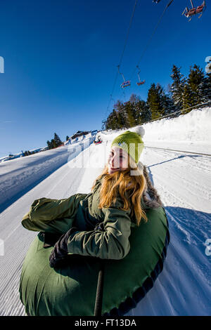 Giovane donna snow tubing, Kreischberg, Murau, Stiria, Austria Foto Stock