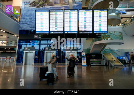 I passeggeri con le valige scorrevoli passando per la pianificazione del volo pensione a Dublin Airport Terminal 2 a Dublino, Irlanda Foto Stock