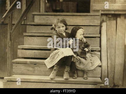 Ritratto ragazza giovane avendo cura di Baby sorella mentre il resto della famiglia di lavoro è locale Cannery Bayou La Batre Alabama USA circa 1911 Foto Stock