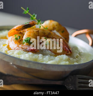 Gamberi e grits con il rametto di timo. Foto Stock