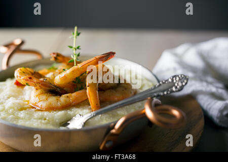 Gamberi e grits con il rametto di timo. Foto Stock