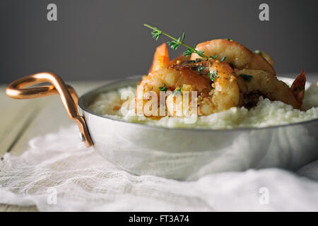 Gamberi e grits con il rametto di timo. Foto Stock