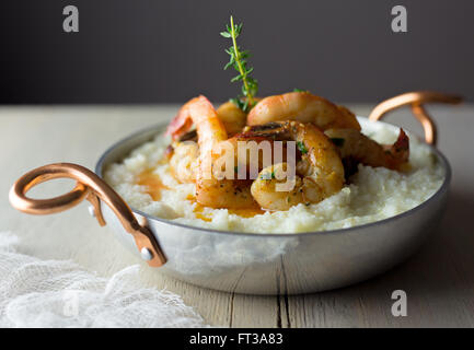 Gamberi e grits con il rametto di timo. Foto Stock