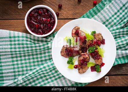 Fegatini di pollo con salsa di mirtilli e lattuga. Vista superiore Foto Stock