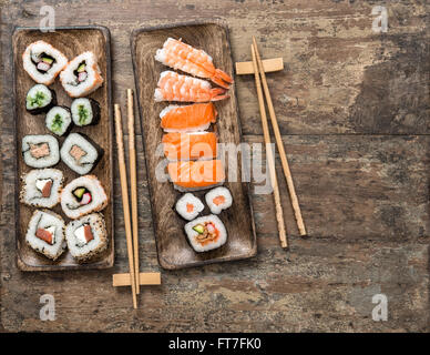 Tradizionale Giapponese del cibo. Sushi rotoli maki e nigiri sul legno rustico sfondo. Frutti di mare Foto Stock