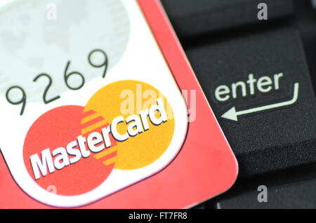 Primo piano della MasterCard carta di debito sulla tastiera del notebook. Foto Stock