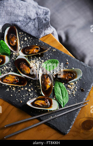 Piatto asiatico - le cozze in sticky salsa dolce, con arachidi e spinaci Foto Stock