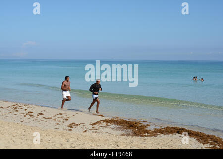 Due uomini in esecuzione su una spiaggia a Cuba Foto Stock