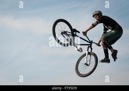 Biker con bici BMX saltare in aria eseguendo stunt dirt jumping Foto Stock