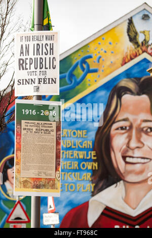 Parte occidentale di Belfast, Irlanda. 25 marzo, 2016. Sinn Fein posters con la proclamazione dell'Irlanda attaccato ad un lampione nella parte occidentale di Belfast. con un murale di Bobby Sands in background questo è in preparazione per la commemorazione del centenario della Pasqua che aumenta Credito: Bonzo Alamy/Live News Foto Stock