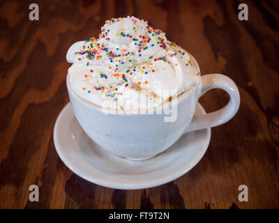 Un caldo Torta di compleanno latté con granelli colorati e panna montata dal d'Lish da Tish Café di Saskatoon, Saskatchewan, Canada. Foto Stock