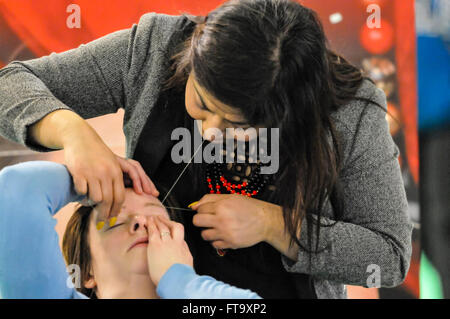 Lisburn, Irlanda del Nord. 25 mar 2016 - una donna riceve un Indiano sopracciglia trattamento di threading per sagomare le sopraciglia Foto Stock