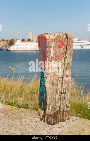 Vecchio weathered e splendidamente colorata polo di ormeggio nel porto di West-Terschelling nel nord dei Paesi Bassi Foto Stock