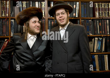 2 religiosa ebraica giovani uomini in una sinagoga di Brooklyn, a New York sulla festa di Purim. Essi sono stati la raccolta di donazioni per i poveri. Foto Stock