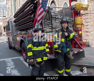 Un ritratto di due vigili del fuoco dalla società del motore 55 di fronte al loro carrello in Lower Manhattan, New York City Foto Stock