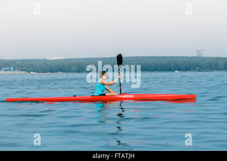 Chelyabisk, Russia - 25 Giugno 2015: ragazza giovane atleta righe su un unico kayak sul lago durante il campionato il canottaggio, il kayak Foto Stock