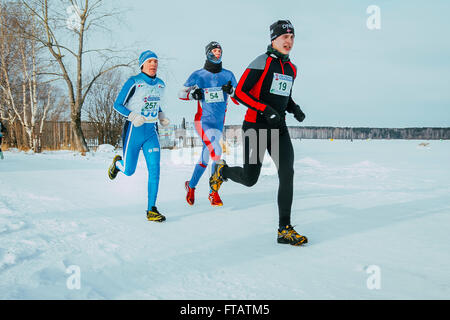 Ekaterinburg, Russia - 14 Novembre 2015: gruppo di uomini, leader gara lungo la riva lago ghiacciato durante l urban winter marathon Foto Stock