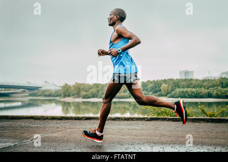 Omsk, Russia - 20 Settembre 2015: giovani runner keniota John Kyui corre lungo il fiume durante il Siberiano maratona internazionale Foto Stock
