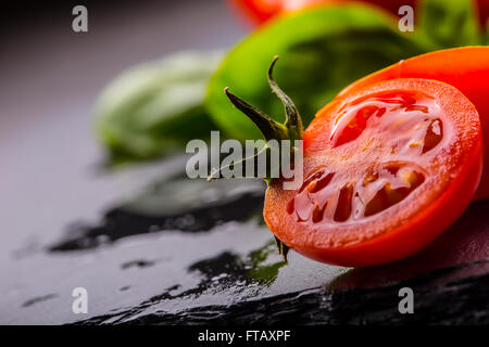 I pomodori. Pomodori ciliegini. Cocktail di pomodori. Mosti di uve fresche pomodori caraffa con olio d'oliva sul tavolo. Tonica foto Foto Stock